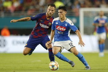 MIAMI, FLORIDA - AUGUST 07: Elif Elmas #12 of Napoli dribbles with the ball against Ivan Rakitic of FC Barcelona during a pre-season friendly match at Hard Rock Stadium on August 07, 2019 in Miami, Florida.  