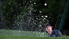 Rory McIlroy plays a shot out of a bunker on the 18th green. 