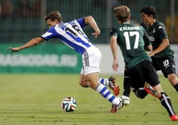 El centrocampista de la Real Sociedad Sergio Canales pelea un balón con los jugadores del Krasnodar, Vitali Kaleshin y Odil Ahmedov.