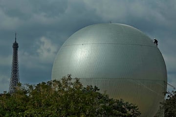 Un operario realiza trabajos de desmontaje del globo que sujetaba el pebetero durante los Juegos Olímpicos y Paralímpicos de París 2024, con la Torre Eiffel al fondo. El pebetero, diseñado por Mathieu Lehanneur, ha permanecido en tierra durante el día, en el Jardín de las Tullerías, y por la noche se elevaba 30 metros sobre París.