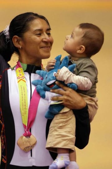 La ciclista celebra su Oro en los panamericanos con su hijo.