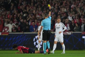 El rbitro del partido, Maurizio Mariani, muestra la cartulina a Luka Modric por cortar un contraaque del jugador del Lille, Tiago Santos.