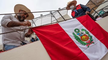 Spectators hang a Peruvian flag over a stage rim prior to the opening bullfight of the 2021 season at the Esperanza bullring in Pachacamac, Peru, on November 13, 2021. - Peru's bullfighting, about as popular as soccer in the South American nation, made its much-anticipated return this weekend to the rings of Lima after a lengthy pandemic-induced hiatus. Over 3,000 spectators attended the first bullfights since the Covid-19 outbreak in March 2020. The practice arrived in the Americas with Spanish conquistadors in the 16th century, and to this day the show attracts thousands of Peruvians of all social classes. The country has more bullrings than football stadiums.xA0 (Photo by Cris BOURONCLE / AFP)
