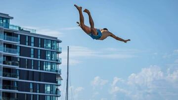 Joan Florit 'Fly' en pleno salto de Death Diving con un edificio y el cielo azul con algunas nubes al fondo.