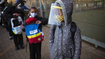 Johannesburg (South Africa), 13/08/2020.- Children wait outside the school gate while wearing protective clothing in the form of masks and face shields as part of their safety due to the Covid-19 coronavirus pandemic, in Johannesburg, South Africa, 13 Aug