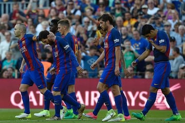 Barcelona's Argentinian forward Lionel Messi (L) is congratulated by Barcelona's midfielder Andres Iniesta (L) after scoring a goal during the Spanish league football match FC Barcelona vs Villarreal CF at the Camp Nou stadium in Barcelona on May 6, 2017.