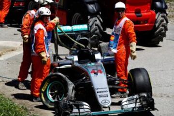 Los operarios retiran el coche de Hamilton tras su golpe con Rosberg.