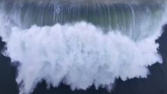 Una ola gigante, rompiendo y generando una espuma muy grande, vista justo desde arriba, en octubre del 2023 en Praia do Norte, Nazaré, Portugal.