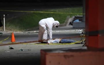 IM?GENES SENSIBLES. Forenses llegan para realizar el proceso de levantamiento del cuerpo de una de las 12 personas que fallecieron en una estampida en el Estadio Cuscatl¨¢n.