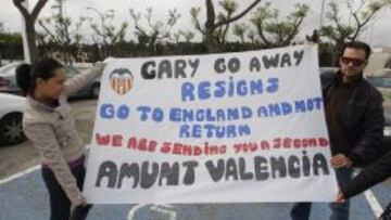 Aficionados del Valencia el lunes con una pancarta pidiendo la dimisi&oacute;n de Neville. 