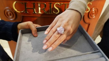 An employee poses with a 15.81 carat fancy vivid purple pink diamond ring, which is called The Sakura Diamond, during a preview at Christie’s ahead of the upcoming auction, in Hong Kong, China May 6, 2021. REUTERS/Joyce Zhou