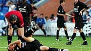 <b>POR LOS SUELOS</B>. Losantos Omar se interesa por Guti después de que éste sufriera un golpe en la cara en un encontronazo con Bermejo.