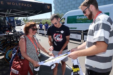 Matteo Cattaneo, ganador del último maillot solidario, firma la prenda en La Vuelta. 