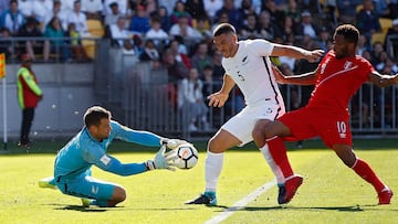 Marinovic controlando una pelota en medio del bloqueo de Reid a Farfán.