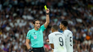 Munuera Montero muestra la tarjeta amarilla a Mbappé.