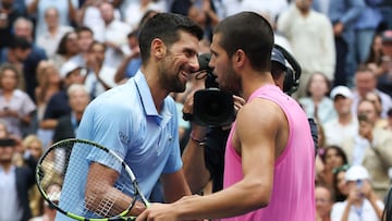 Spain's Carlos Alcaraz and Serbia's Novak Djokovic (L) hug at the net after Alcaraz's victory in their men's singles semifinal tennis match on day thirteen of the US Open tennis tournament at the USTA Billie Jean King National Tennis Center in New York City, on September 5, 2025. (Photo by TIMOTHY A. CLARY / AFP)