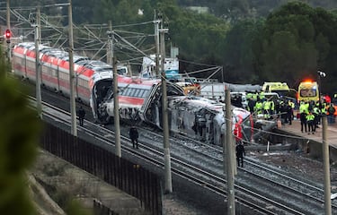 Miembros de la Guardia Civil junto con otros efectivos de emergencia, trabajan junto a uno de los trenes implicados en el accidente, en el lugar del descarrilamiento mortal de dos trenes de alta velocidad cerca de Adamuz, en Córdoba.
