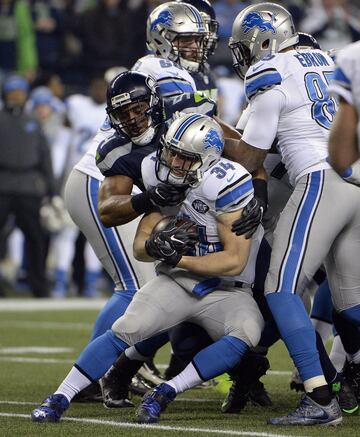 Zach Zenner es placado por el middle linebacker Bobby Wagner en los primeros lances del partido.