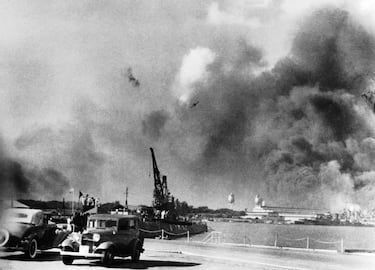 Durante el ataque japonés a Pearl Harbor, un avión de combate japonés ZERO sobrevuela la base aérea de la marina. El humo a lo lejos proviene de los aviones de combate impactados cerca de la isla Ford .