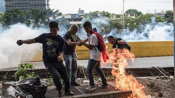 Demonstrators clash with the riot police during a protest against Venezuelan President Nicolas Maduro, in Caracas on April 20, 2017.
Venezuelan riot police fired tear gas Thursday at groups of protesters seeking to oust President Nicolas Maduro, who have vowed new mass marches after a day of deadly unrest. Police in western Caracas broke up scores of opposition protesters trying to join a larger march, though there was no immediate repeat of Wednesday's violent clashes, which left three people dead. / AFP PHOTO / CARLOS BECERRA