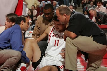 Mark Adickes and Hussein Elkousy, Team Physicians of the Houston Rockets, sit with Yao Ming of the Houston Rockets after he injured his right knee 23 December 2006 at the Toyota Center in Houston, Texas.