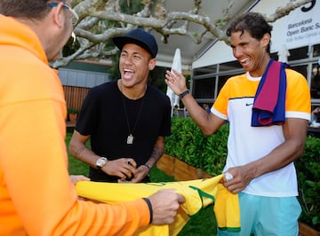 Rafa Nadal r赤e mientras Neymar, entonces jugador del FC Barcelona, ??firma aut車grafos durante la tercera jornada del Barcelona Open de 2015.