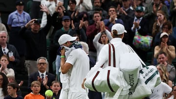 Bulgaria's Grigor Dimitrov (L) leaves the court flanked by Italy's Jannik Sinner after withdrawing following an injury during the men's singles fourth round tennis match on the eighth day of the 2025 Wimbledon Championships at The All England Lawn Tennis and Croquet Club in Wimbledon, southwest London, on July 7, 2025. (Photo by Adrian Dennis / AFP) / RESTRICTED TO EDITORIAL USE