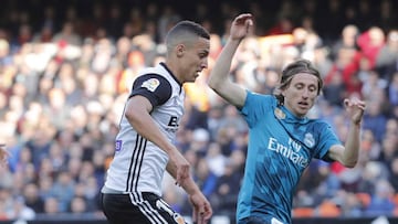 Luka Modric intentado robar un balón a Rodrigo.