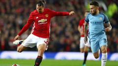 MANCHESTER, ENGLAND - OCTOBER 26: Zlatan Ibrahimovic of Manchester United (L) shoots while Nicolas Otamendi of Manchester City (R) watches on during the EFL Cup fourth round match between Manchester United and Manchester City at Old Trafford on October 26, 2016 in Manchester, England.  (Photo by Michael Steele/Getty Images)