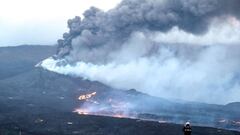 In this handout photograph taken on November 17, 2021 and released by the Spanish Military Emergency Unit (UME) on November 18, 2021, an UME member monitors the lava flows from La Laguna, following the eruption of the Cumbre Vieja volcano on the Canary is