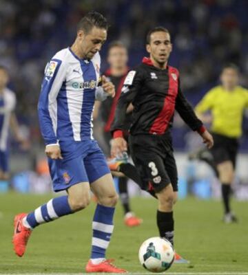 El delantero del RCD Espanyol Sergio García (i) con el balón ante el Rayo Vallecano Nacho Martínez (d), durante el partido de Liga en Primera División que disputan esta noche en el estadio de Cornellà-El Prat, en Barcelona. 