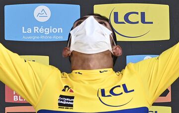 Team Education First rider Colombia's Daniel Martinez celebrates his overall leader's yellow jersey on the podium at the end of the  fifth stage of the 72nd edition of the Criterium du Dauphine cycling race, 153 km between Megeve and Megeve on August 16, 2020. (Photo by Anne-Christine POUJOULAT / POOL / AFP)