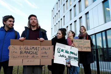 Activists protest outside the District Court of West Lausanne before the trial of twelve activists for a protest inside a branch of Credit Suisse bank in 2018 in Renens, Switzerland, January 7, 2020. The banner reads : If climate was a bank they would hav