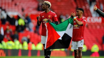 Manchester United's French midfielder Paul Pogba (L) and Manchester United's Ivorian midfielder Amad Diallo (R) walk around the pitch at the end of the game during the English Premier League football match between Manchester United and Fulham at