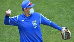 Un entrenador de los Yokohama DeNA BayStarslleva una mascarilla durante el partido de entrenamiento ant el Tohoku Rakuten Golden Eagles.