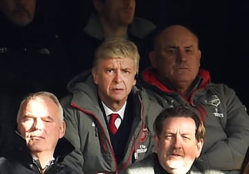 Arsenal manager Arsene Wenger watches his team from the stands during a Premier League soccer match against Arsenal at Stamford Bridge in London