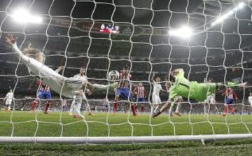 FEBRERO 2014. El centrocampista croata del Real Madrid Luka Modric despeja un balón bajo palos junto al portero, Iker Casillas, durante el partido de ida de las semifinales de la Copa de Rey disputado en el estadio Santiago Bernabéu ante el Atlético de Madrid.