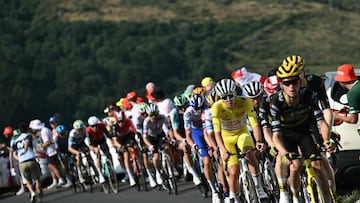 Team Visma - Lease a bike team's US rider Sepp Kuss (R) cycles ahead of UAE Team Emirates - XRG team's Slovenian rider Tadej Pogacar wearing the overall leader's yellow jersey and the pack of riders (peloton) cycles during the 10th stage of the 112th edition of the Tour de France cycling race, 165.3 km between Ennezat and Le Mont-Dore Puy de Sancy, in central France, on July 14, 2025. (Photo by Marco BERTORELLO / AFP)
