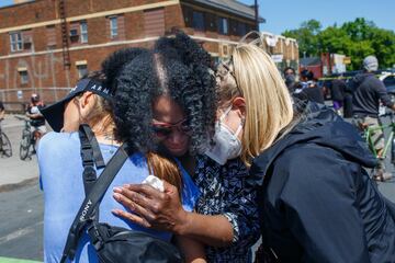 Friends of George Floyd hug and cry by a makeshift memorial in honor of George Floyd, who died while in custody of the Minneapolis police, following a day of demonstration in a call for justice on May 30, 2020 in Minneapolis, Minnesota. - Demonstrations are being held across the US after George Floyd died in police custody on May 25. (Photo by Kerem Yucel / AFP)