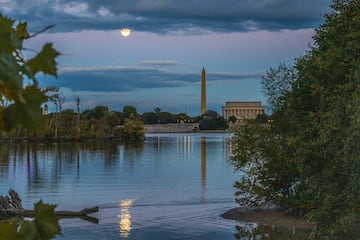 La "Superluna del Cazador" con un aumento del 99,5 por ciento, se refleja en el río Potomac cuando se eleva detrás del monumento a Lincoln y el monumento a Washington.