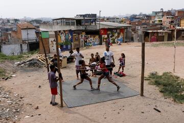 Mariangela, de 13 años, y Sofia, de 11, combaten durante una sesión de entrenamiento en un improvisado ring montado en Capao Redondo (Sao Paulo), una de las zonas más desfavorecidas de Brasil. Está claro que cualquier lugar es bueno para practicar deporte, aunque sea rodeado de favelas.