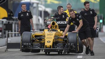 Mecánicos de Renault empujan el monoplaza de Kevin Magnussen.