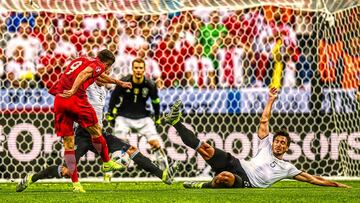 Poland&#039;s forward Robert Lewandowski (L) shoots the ball during the Euro 2016 group C football match between Germany and Poland at the Stade de France stadium in Saint-Denis near Paris on June 16, 2016. / AFP PHOTO / FRANCK FIFE