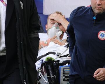 El jugador dan¨¦s, ya consciente, es retirado en camilla para ser trasladado al hospital.