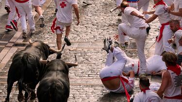 Participantes corren delante de los toros durante el primer encierro de los Sanfermines en Pamplona.