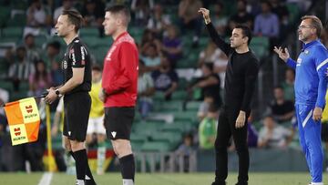 Xavi, junto al línea y el cuarto árbitro en el Betis-Barcelona.