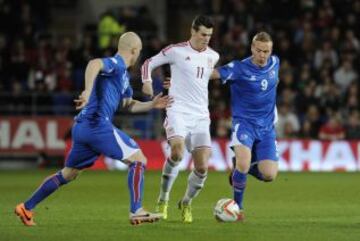 Gareth Bale es desafiado por Kolbeinn Sigthorsson de Islandia y Emil Hallfredsson durante el partido de fútbol amistoso internacional en el Estadio Cardiff City