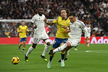 MADRID, 19/01/2025.- El delantero portugus de Las Palmas Fbio Silva (c) pelea el baln ante la marca de los jugadores madridistas, Antonio Rdiger y Ral Asencio (d), este domingo, durante un partido de la jornada 20 de LaLiga EA Sports, entre el Real Madrid y el UD Las Palmas, en el Estadio Santiago Bernabu de Madrid. EFE/ Fernando Villar
