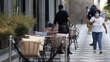 Un camarero prepara una terraza de un bar