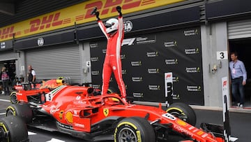 TOPSHOT - Ferrari's German driver Sebastian Vettel stands on his car in the pits after winning the Belgian Formula One Grand Prix at the Spa-Francorchamps circuit in Spa on August 26, 2018. (Photo by EMMANUEL DUNAND / AFP)